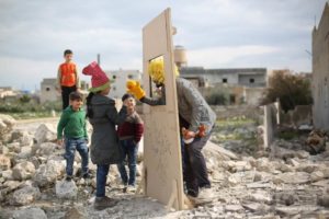 Bambini in un campo profughi siriano guardano il teatro delle marionette