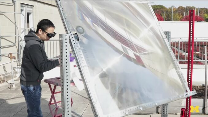 Peng Zhou Michigan University utilizza una grande lente per convogliare luce solare su contenitore
