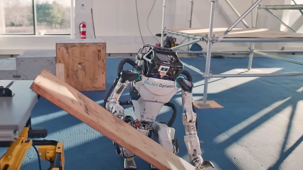 Atlas Boston Dynamics s’inginocchia per afferrare asse di legno di 7,5 kg