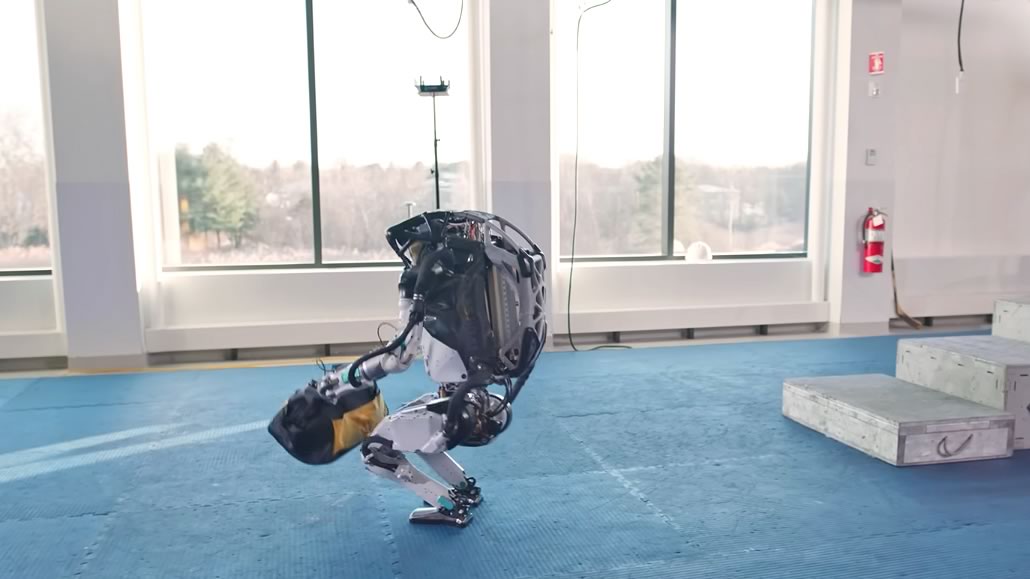 Atlas Boston Dynamics solleva borsa attrezzi bilanciandosi leggermente all’indietro
