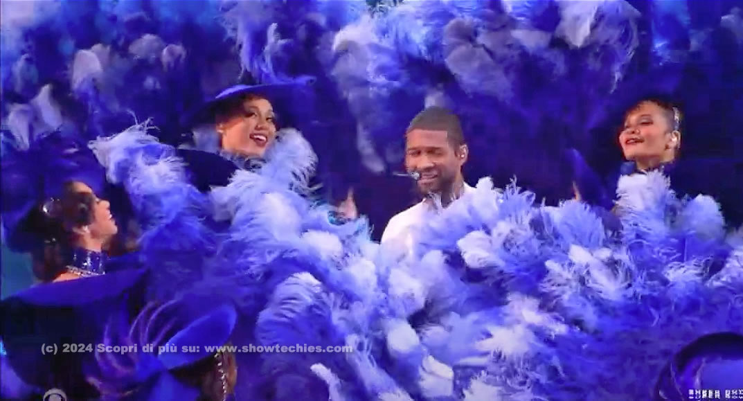 Usher circondato dai ventagli di piume delle ballerine