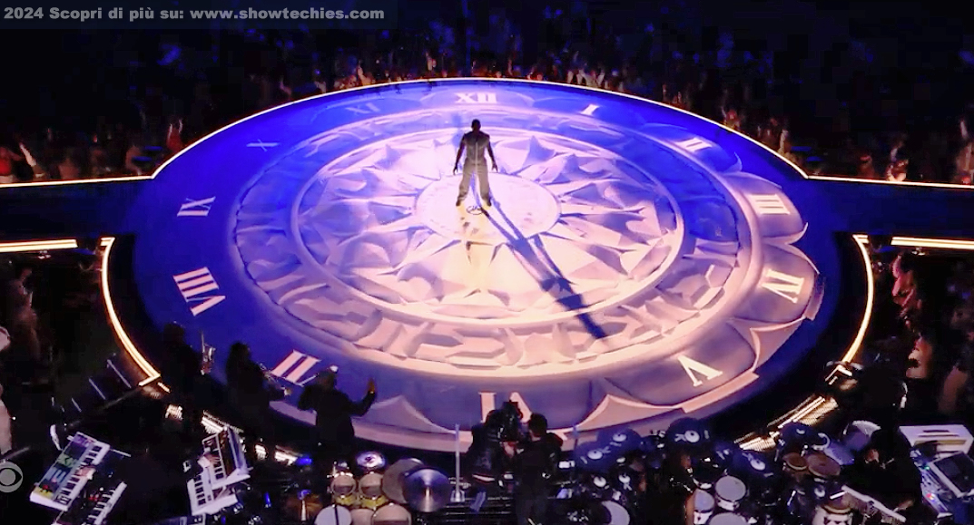 Proiezione orologio su palco circolare durante canzone "Alle sette, in punto..."